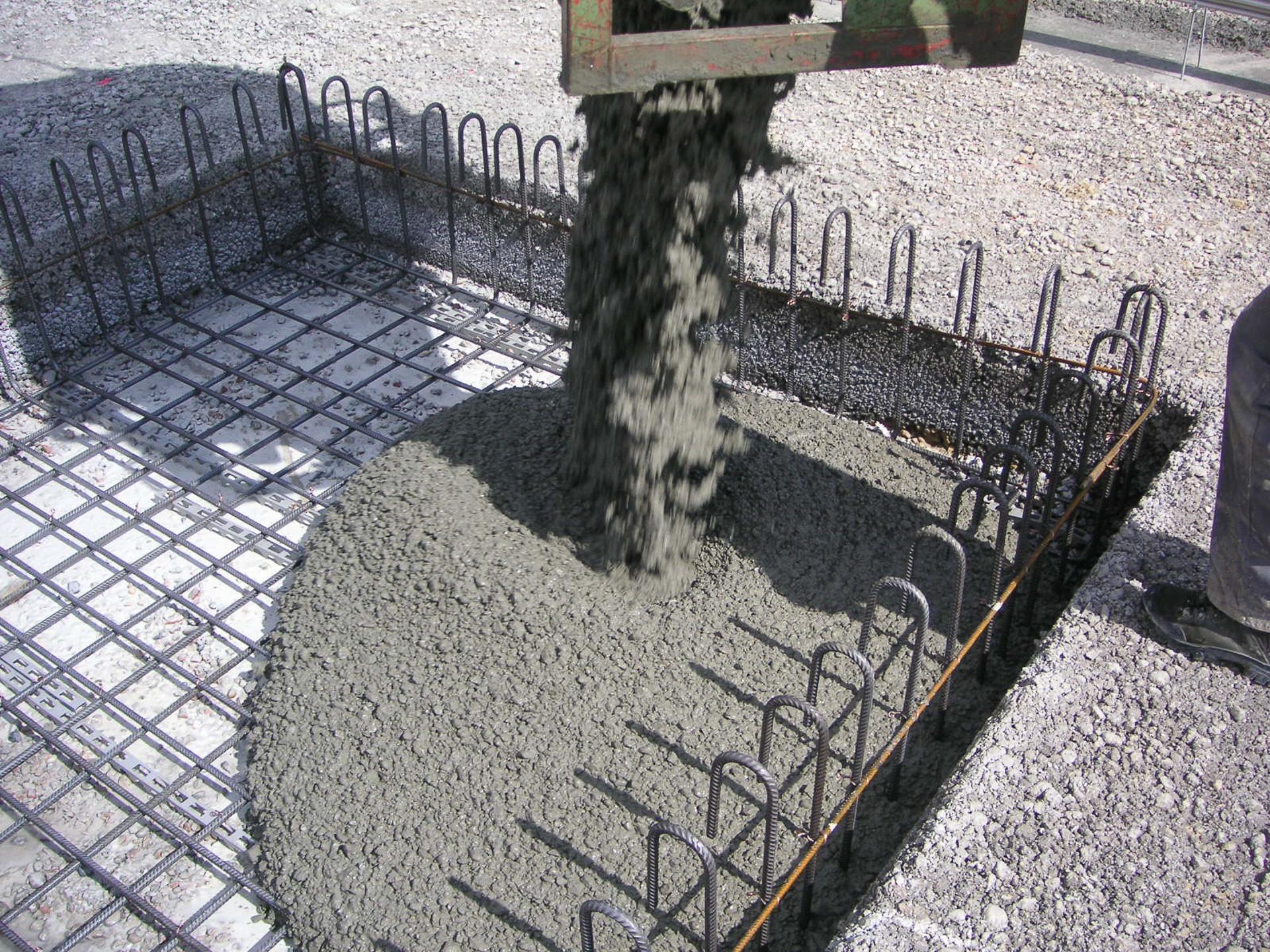 Flüssige Betonmischung wird in eine Form mit stabilisierenden Eisenstangen gegossen.