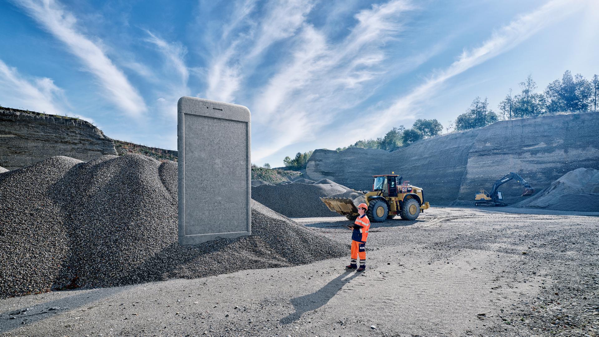 keyvisual von Vigier Beton: Ein Mitarbeiter steht vor einem riesigen Beton-Smartphone
